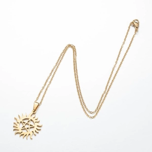 Detail of gold horseshoe necklace with sunburst and hollow star pendant on white background