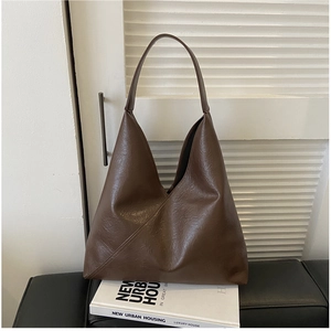 Detailed macro view of dark brown pebbled faux leather texture on retro tote bag