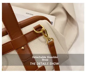 Detail view of the detachable shoulder strap hook on the beige and brown leather handbag