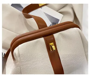 Close-up of contrast leather texture and golden twist lock on vintage shell bag
