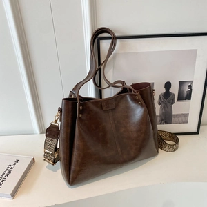 Retro large brown tote bag with ethnic woven wide shoulder strap on white stand