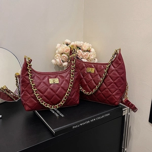 Borsa a secchiello trapuntata rosso scuro con catena dorata e motivo a rombi