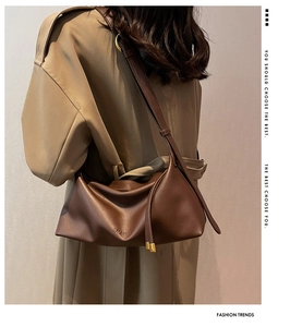 Close-up of the soft lychee leather texture and FASHION embossing on a brown tote bag
