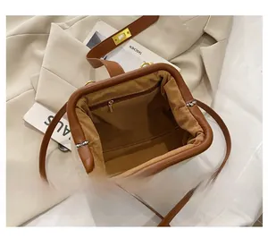 Detailed interior of vintage shell bag showing brown lining and zippered inner pocket