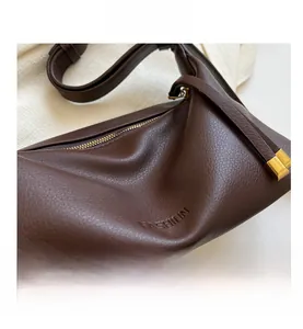 Close-up of deep brown pebbled leather texture and embossed FASHION lettering on tote bag
