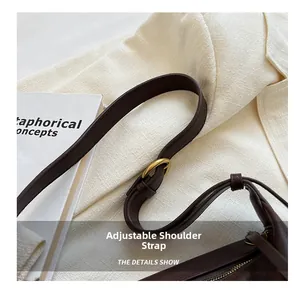 Detail of adjustable shoulder strap with gold buckle on dark brown leather tote bag
