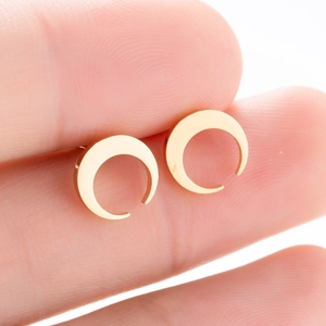 Vue macro des boucles d'oreilles croissant de lune dorées en acier inoxydable matifié