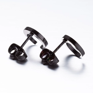 Détail macro de boucles d'oreilles lune noires minimalistes en acier inoxydable mat