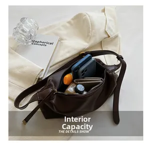 Detail view of large brown soft leather tote bag showing spacious interior with essentials