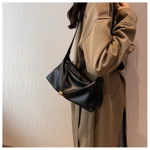 Detail of soft black leather tote with gold hardware and natural grain texture