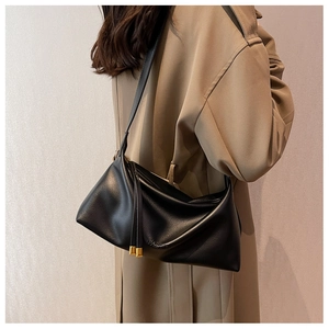 Detail of soft black leather tote bag with FASHION embossing and gold metal zippers