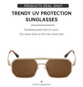 Détail de lunettes de soleil carrées avec branches dorées et verres bruns anti-UV