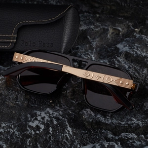 Détail de lunettes de soleil de luxe avec branches dorées ornées de gravures stellaires