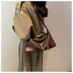 Detailed view of dark brown pebbled leather tote bag with FASHION embossed logo and gold hardware