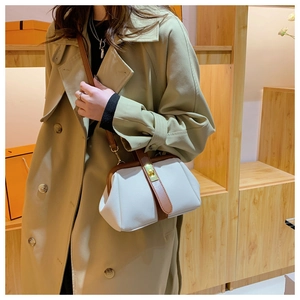 Close-up of vintage shell-shaped bag with brown handles and golden turn-lock closure