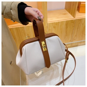 Detail of vintage shell bag with lychee texture and contrast brown handle straps