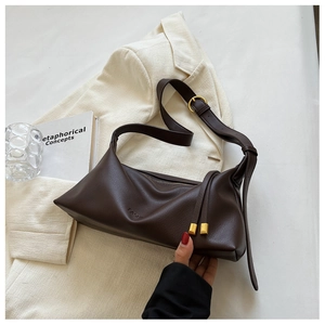 Detail of dark brown lychee texture leather tote with gold metal buckle and fashion logo