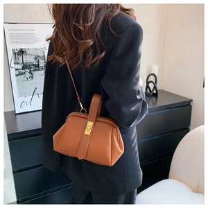 Brown litchi grain leather crossbody bag featuring vintage metal buckle and structured shape