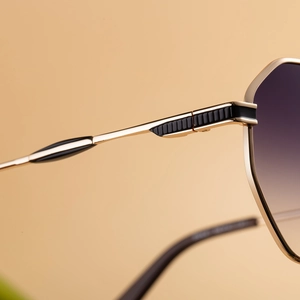 Vue macro des lunettes de soleil en métal doré avec verres dégradés et charnière