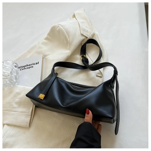 Close-up of black leather hobo bag with Fashion embossing and gold metal buckles