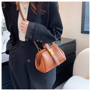 Close-up of brown litchi pattern doctor bag with vintage metal clasp and leather strap