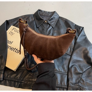 Detailed close-up of dark brown suede croissant bag with vintage gold metal zipper