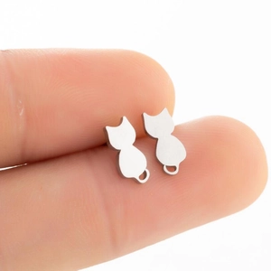 Macro view of minimalist hollow cat-shaped stainless steel stud earrings in silver