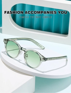 Détail de lunettes de soleil rondes vert clair translucides avec verres dégradés