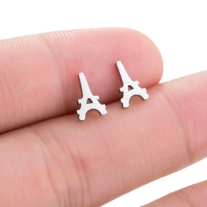 Detailed view of silver Eiffel Tower stud earrings held by hand to show compact size