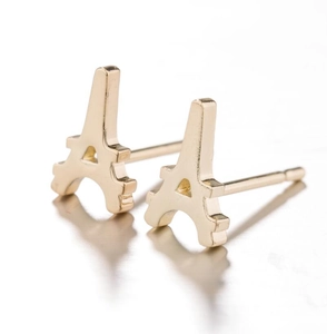 Detailed view of 3D Eiffel Tower shaped gold stud earrings on a reflective white background