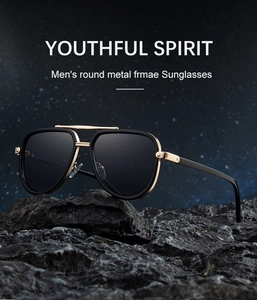 Close-up of aviator sunglasses with gold metal frame on a dark mineral stone base