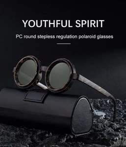 Detail view of round polarized sunglasses with camo frame on rock texture