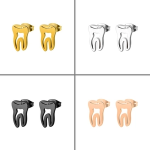 Detail of tooth-shaped stud earrings in gold, silver, black and rose gold steel