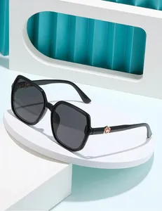 Detail of square polarized sunglasses with gold geometric logo on black temples