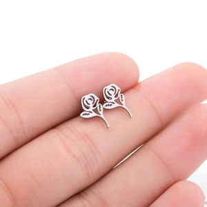 Gros plan de boucles d'oreilles roses origami en argent montrant leur taille miniature