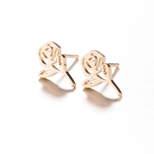 Gros plan sur les boucles d'oreilles roses dorées avec design ajouré en métal fin