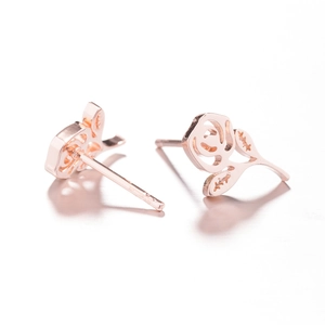 Détail de boucles d'oreilles fleur en or rose avec motif rose évidé et fini métal poli