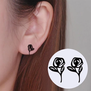 Boucles d'oreilles roses noires élégantes avec détails de feuilles sur un mannequin