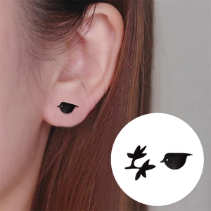 Minimalist black bird stud earrings for women with matte finish on earlobe model