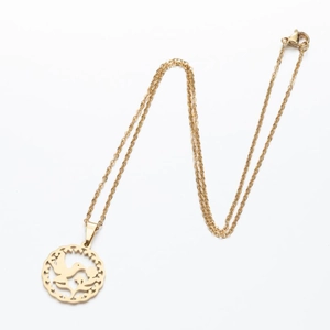 Detail view of a gold hollow geometric bird and leaf pendant on a fine link chain
