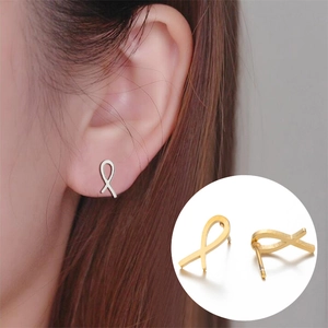 Detail view of ribbon shaped stud earrings in silver and gold polished finishes