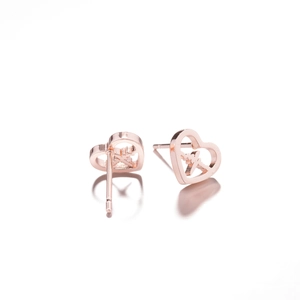 Macro shot of rose gold heart stud earrings with heartbeat cutout design and 18K plating