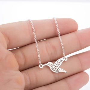 Macro view of a hollow hummingbird necklace pendant in polished silver finish