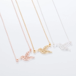 Detailed view of hummingbird pendant necklaces in rose gold, yellow gold, and silver finishes