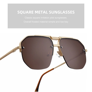 Detail view of gold matte metal temples and brown lenses on retro aviator sunglasses