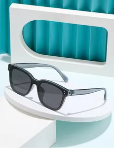 Détail de lunettes de soleil carrées gris translucide avec verres fumés et branches stylées