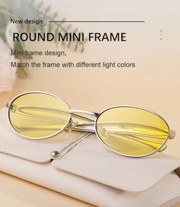Close-up of retro oval sunglasses with yellow lenses and silver metal frame with leather pouch