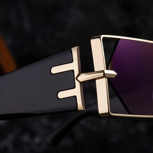 Detailansicht der goldenen Metallscharniere und schwarzen Bügel dieser modischen Sonnenbrille