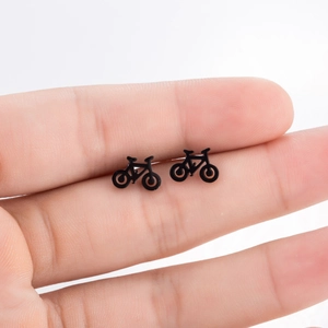 Boucles d'oreilles vélo noires minimalistes montrées sur le doigt pour la taille