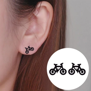 Boucles d'oreilles vélo minimalistes noir mat pour femmes et hommes portées par le mannequin